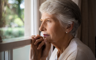 Senior woman looking out of window - risk of dementia
