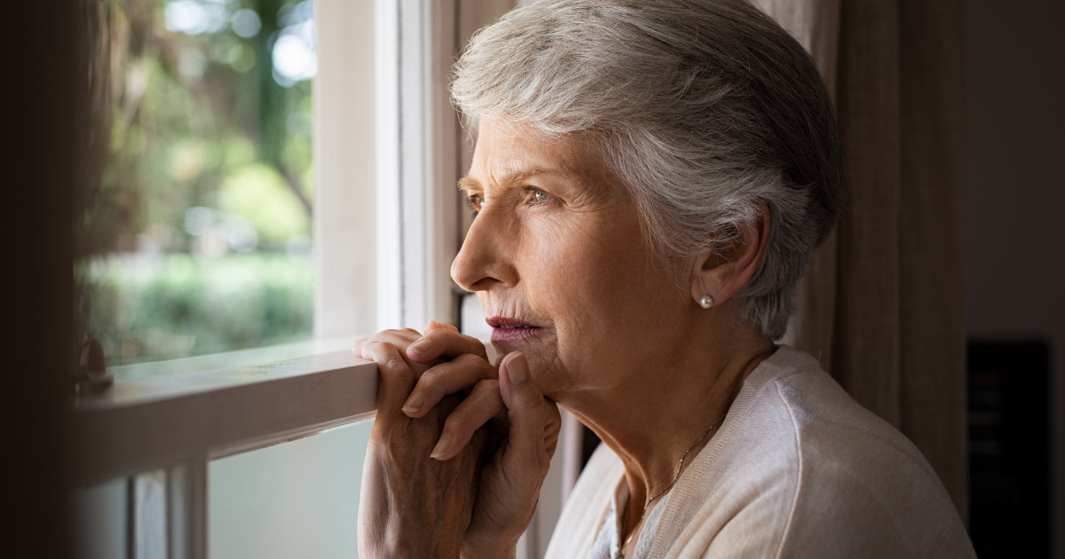 Senior woman looking out of window - risk of dementia