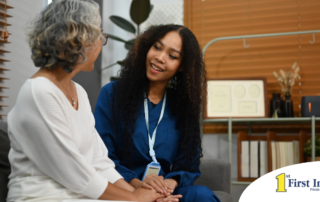 A caregiver patiently and kindly sits down and talks with a senior client, setting a good example for caregivers when it comes to communication.