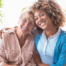 A caregiver enjoys professional caregiving as she helps a senior client.