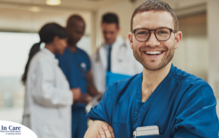 A young man in healthcare smiles, representing how a career as a professional caregiver can lead to a happy career as a healthcare professional.