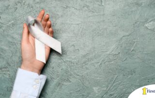 A woman holds a silver ribbon, representing Parkinson’s Awareness Month.