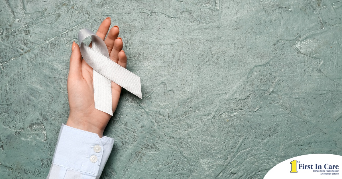 A woman holds a silver ribbon, representing Parkinson’s Awareness Month.