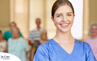 A professional caregiver smiles with seniors behind her, showing how a job with a caregiver agency can be a good choice.