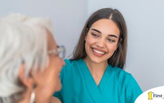 A caregiver smiles with an older client showing the results of successfully starting a new caregiving job.