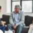 A caregiver talks with an elderly couple representing the kind of communication that professional caregivers need to have to anticipate client needs.