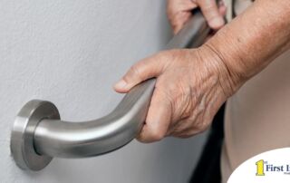 An older adult uses a grab bar representing one of the home modifications that is helpful for fall prevention for elderly adults.