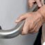 An older adult uses a grab bar representing one of the home modifications that is helpful for fall prevention for elderly adults.