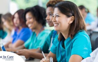 Several students in scrubs happily attend a class, representing caregiver training.