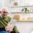 Home caregiver assisting senior man to use telehealth and senior care